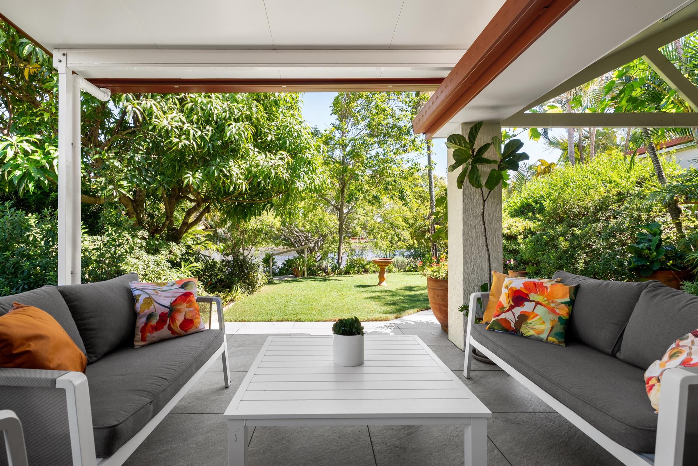 Insulated patio framing a landscaped Gold Coast garden with water views